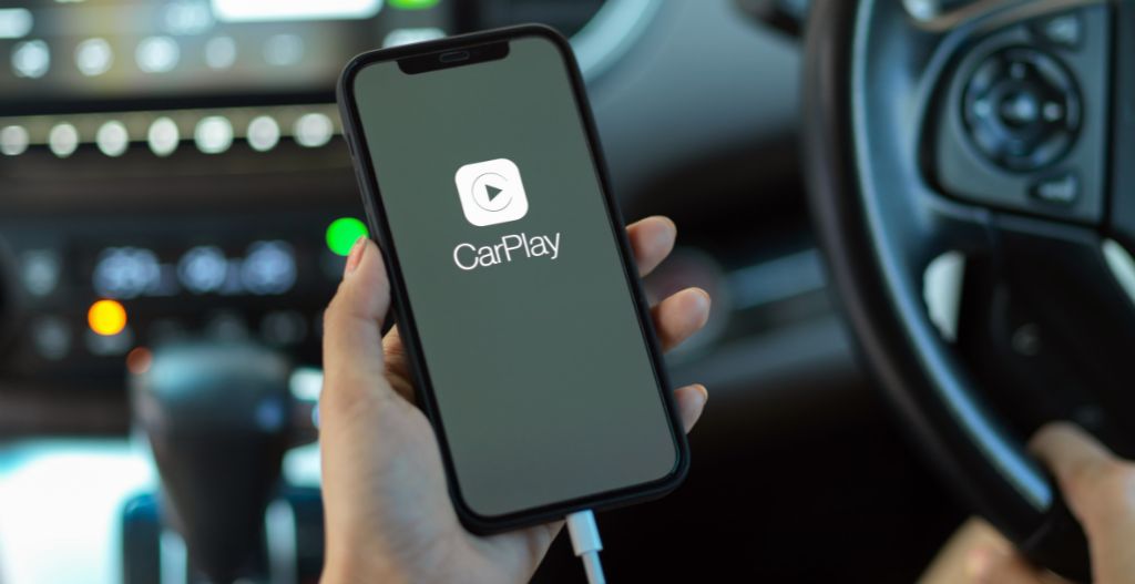 Driver checking Apple CarPlay on an iPhone after an iOS update