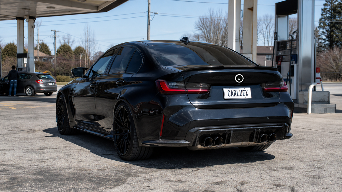Rear three-quarter view of a black BMW M3 fitted with the CARLUEX FRENIX™ Custom LED Badge for BMW digital rear emblem in daylight.